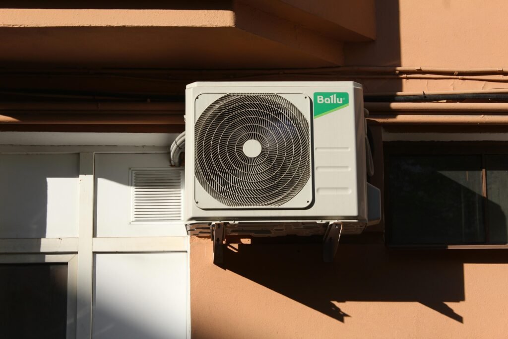 A Ballu air conditioner condenser unit mounted on a building exterior, showcasing modern HVAC technology.